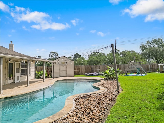 view of pool with a fenced backyard, a playground, and a storage shed