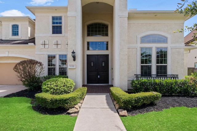 property entrance with a garage and stucco siding