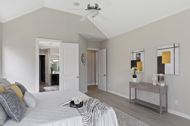 bedroom with connected bathroom, baseboards, wood finished floors, and lofted ceiling