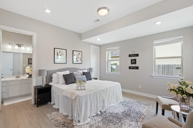 bedroom with visible vents, recessed lighting, a sink, light wood-style flooring, and ensuite bath