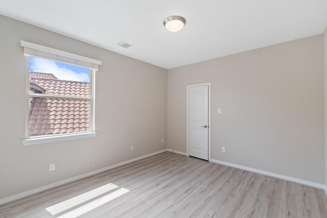spare room with visible vents, baseboards, and light wood-type flooring