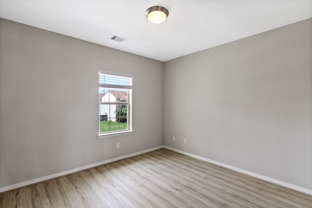 spare room featuring baseboards, visible vents, and light wood-style flooring