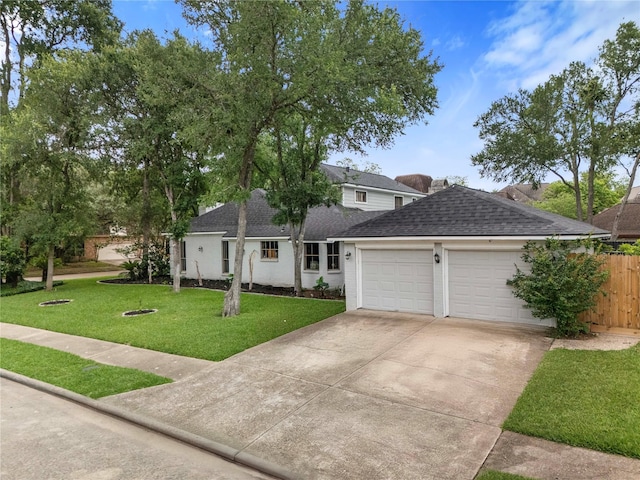 ranch-style house with fence, a shingled roof, a front lawn, a garage, and driveway
