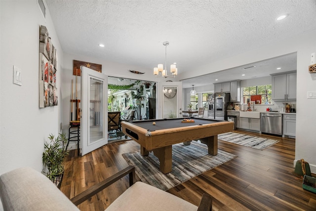 game room with a textured ceiling, pool table, dark wood-style floors, a notable chandelier, and recessed lighting