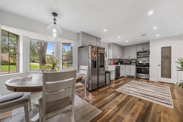kitchen with light countertops, stainless steel appliances, gray cabinetry, and dark wood-style flooring