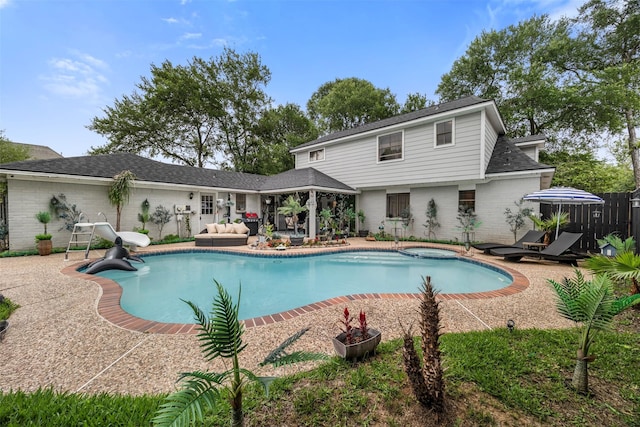 view of swimming pool with outdoor lounge area, fence, a patio, a gazebo, and a water slide
