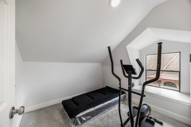 exercise area with baseboards, carpet flooring, and vaulted ceiling