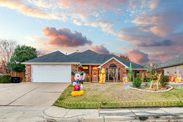 ranch-style home with a garage, a front lawn, roof with shingles, brick siding, and concrete driveway