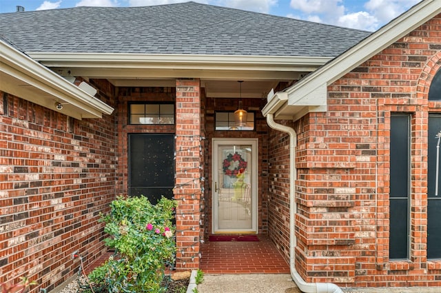 entrance to property with brick siding and roof with shingles