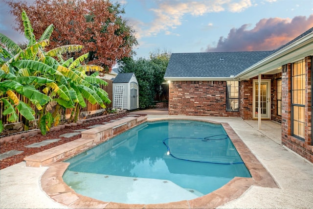 pool featuring a storage unit, an outdoor structure, and a patio area