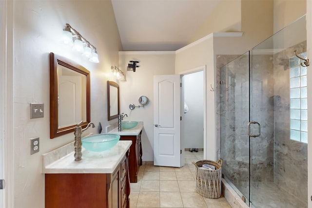 full bath with a sink, tile patterned flooring, vaulted ceiling, and a stall shower