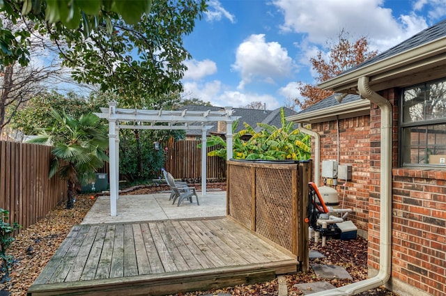 wooden deck with a fenced backyard, a patio area, and a pergola