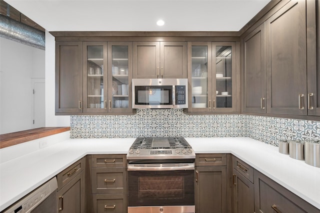 204 Travis St Unit 4A, Houston, TX 77002 - kitchen with light countertops, appliances with stainless steel finishes, decorative backsplash, and glass insert cabinets