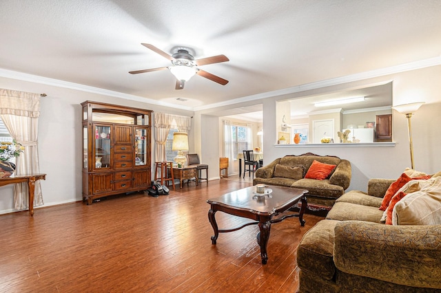 living area with crown molding, baseboards, a ceiling fan, and wood finished floors