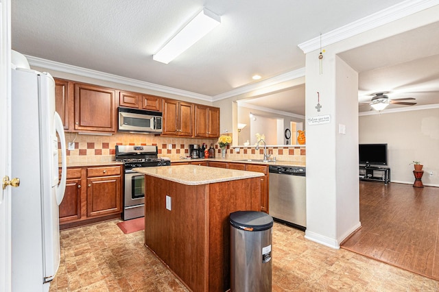 kitchen featuring a sink, appliances with stainless steel finishes, ornamental molding, and brown cabinetry