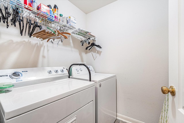 washroom featuring washing machine and clothes dryer, laundry area, and baseboards