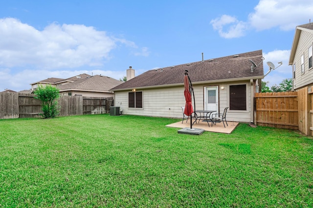 rear view of property with a patio, a fenced backyard, a yard, and cooling unit