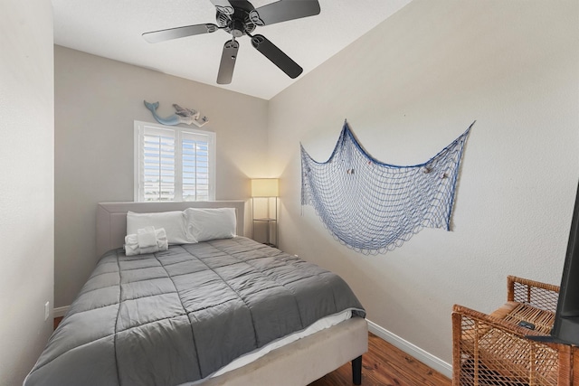 bedroom with baseboards, ceiling fan, and wood finished floors