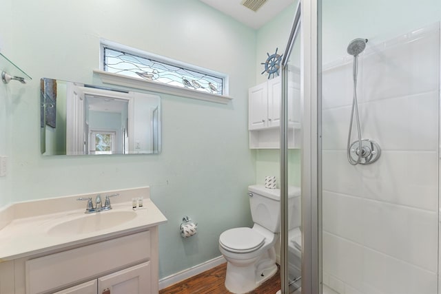 bathroom with vanity, a stall shower, toilet, and wood finished floors