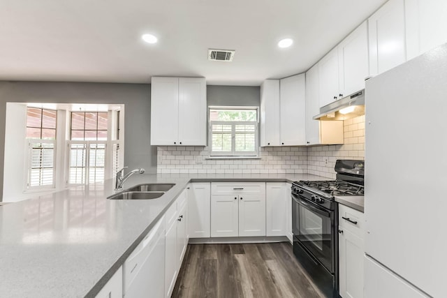 kitchen featuring recessed lighting, a sink, under cabinet range hood, and white appliances