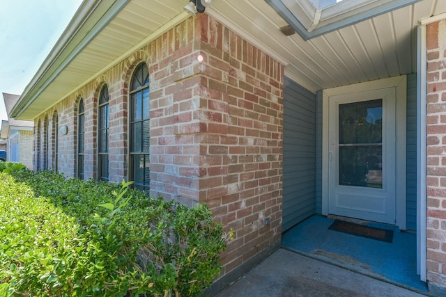 view of exterior entry with brick siding