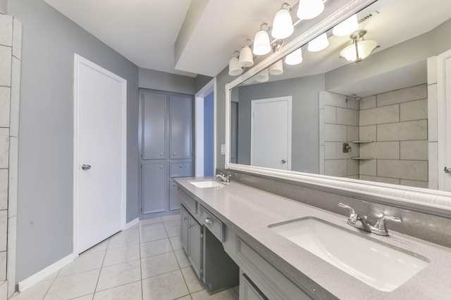 bathroom with baseboards, double vanity, tile patterned floors, and a sink