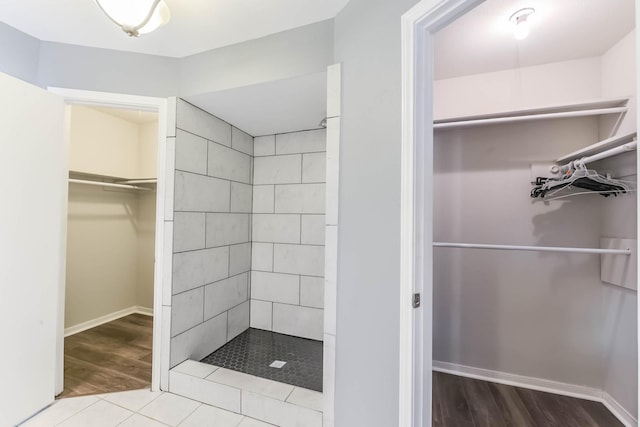 full bathroom with wood finished floors and tiled shower