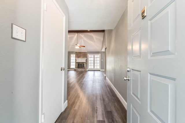 hallway with baseboards, beamed ceiling, and dark wood-type flooring