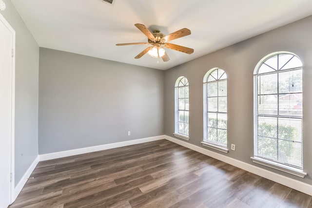 unfurnished room featuring dark wood-style flooring, baseboards, and a ceiling fan