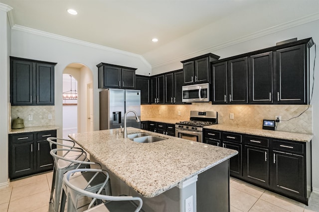 kitchen featuring a sink, appliances with stainless steel finishes, dark cabinetry, and light tile patterned flooring