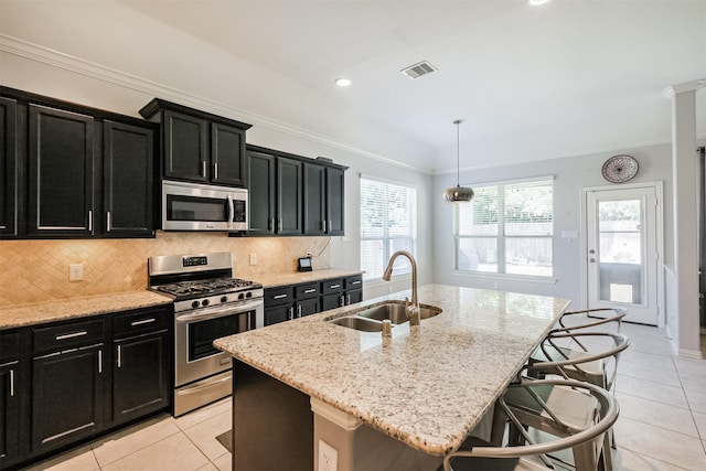 kitchen featuring stainless steel appliances, visible vents, dark cabinets, and a sink