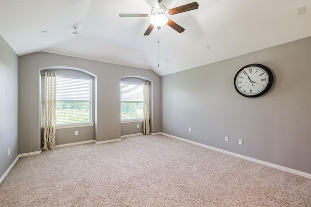 spare room with baseboards, light carpet, a ceiling fan, and lofted ceiling