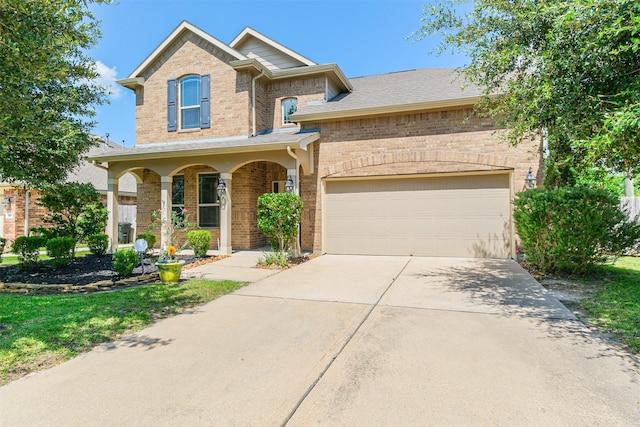 traditional home featuring an attached garage, concrete driveway, a porch, and brick siding