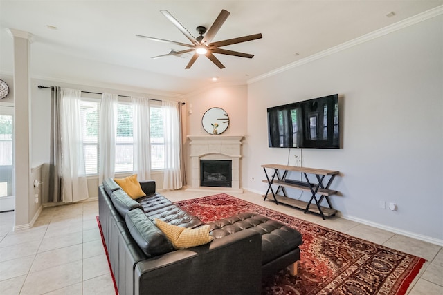 living area with plenty of natural light, a ceiling fan, crown molding, and light tile patterned flooring