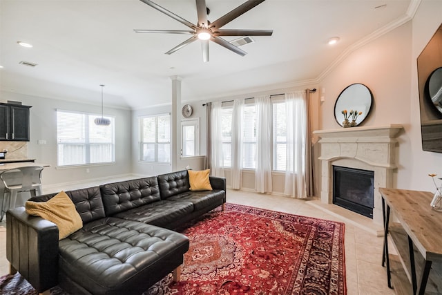 living area with crown molding, light tile patterned flooring, ceiling fan, and a healthy amount of sunlight