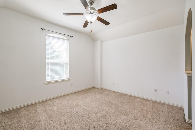 empty room featuring ceiling fan, light carpet, baseboards, and lofted ceiling