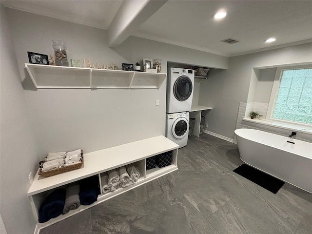 clothes washing area with laundry area, stacked washer and dryer, visible vents, ornamental molding, and recessed lighting