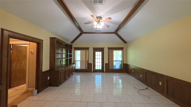spare room featuring visible vents, lofted ceiling, a wainscoted wall, and ceiling fan