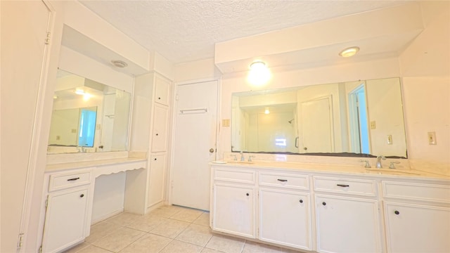 bathroom featuring double vanity, a sink, a textured ceiling, and tile patterned floors