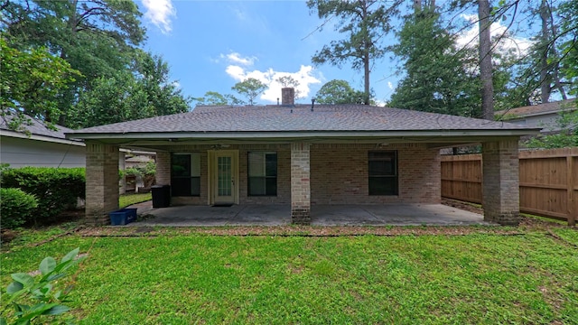 back of property with a patio area, fence, a yard, and a chimney