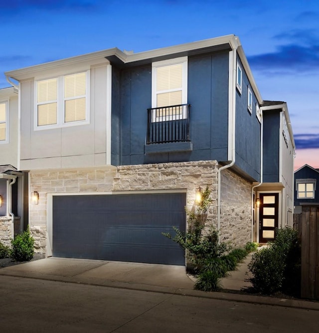 9904 Smokehouse Silo Ln, Houston, TX 77080 - view of front of home featuring stone siding, an attached garage, a balcony, driveway, and stucco siding