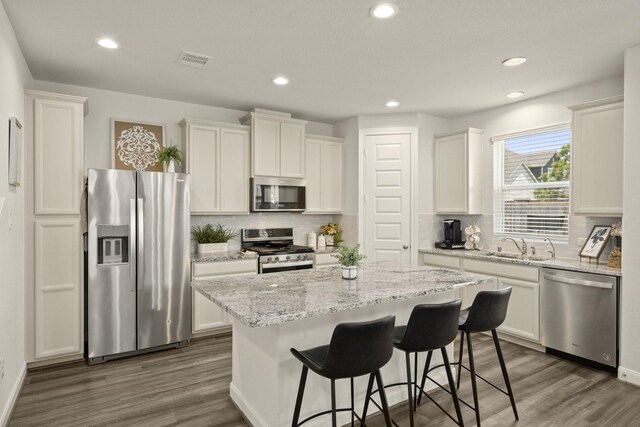 9904 Smokehouse Silo Ln, Houston, TX 77080 - kitchen with stainless steel appliances, a kitchen island, tasteful backsplash, dark wood-style flooring, and recessed lighting