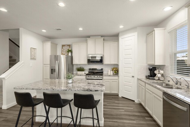 9904 Smokehouse Silo Ln, Houston, TX 77080 - kitchen featuring stainless steel appliances, a sink, a center island, tasteful backsplash, and dark wood finished floors