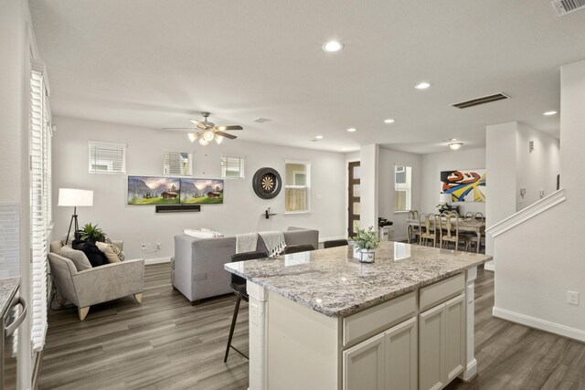 9904 Smokehouse Silo Ln, Houston, TX 77080 - kitchen featuring light wood-style flooring, a kitchen breakfast bar, baseboards, a center island, and recessed lighting