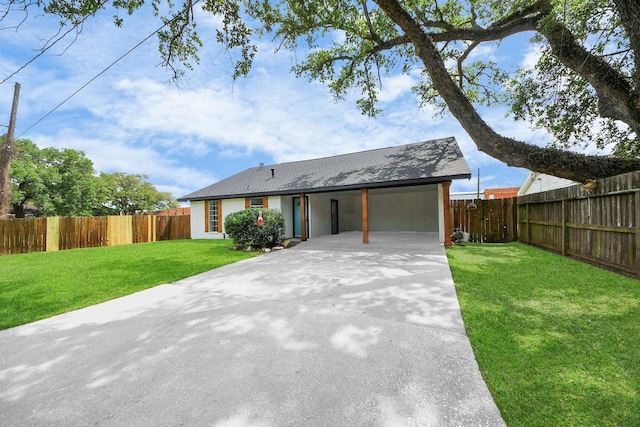 view of front of house with concrete driveway, fence, a carport, and a front lawn