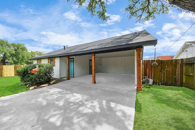 view of front facade featuring concrete driveway, fence, and a front yard