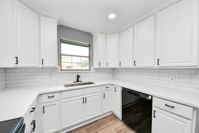 kitchen featuring light wood-type flooring, a sink, electric stove, black dishwasher, and white cabinetry