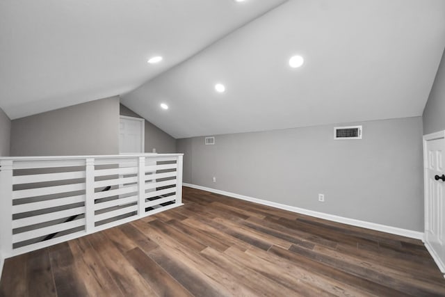 bonus room featuring baseboards, vaulted ceiling, wood finished floors, and visible vents