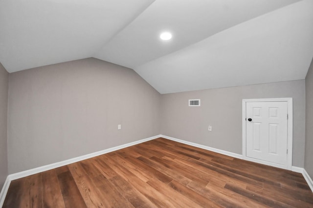 bonus room featuring baseboards, vaulted ceiling, wood finished floors, and visible vents