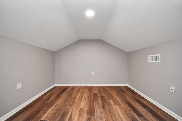 bonus room with visible vents, baseboards, lofted ceiling, and wood finished floors